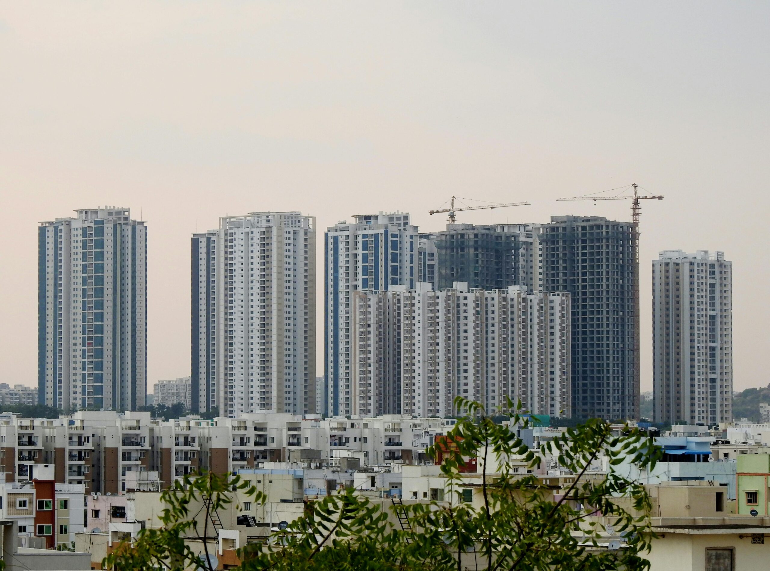 Panoramic view of modern skyscrapers in Hyderabad, India featuring urban development and construction cranes.